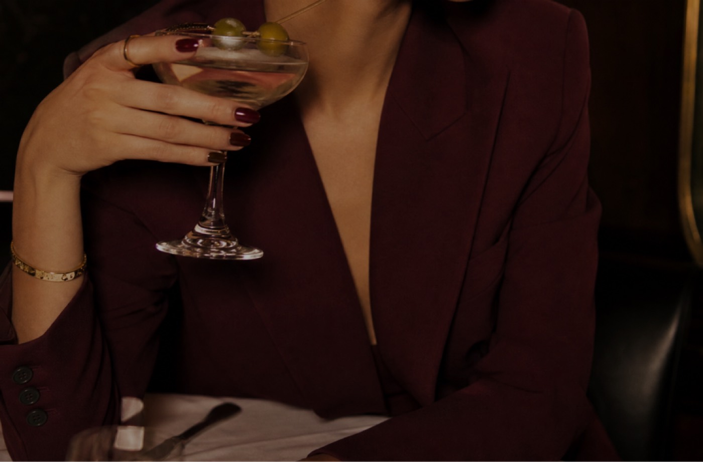 Femme en blazer bourgogne avec un martini